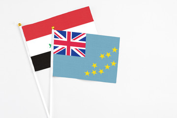 Fototapeta premium Tuvalu and Iraq stick flags on white background. High quality fabric, miniature national flag. Peaceful global concept.White floor for copy space.