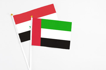 United Arab Emirates and Iraq stick flags on white background. High quality fabric, miniature national flag. Peaceful global concept.White floor for copy space.