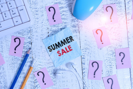 Writing note showing Summer Sale. Business concept for time when a store sells products at much lower prices than usual Writing tools and scribbled paper on top of the wooden table