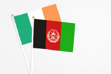 Afghanistan and Ireland stick flags on white background. High quality fabric, miniature national flag. Peaceful global concept.White floor for copy space