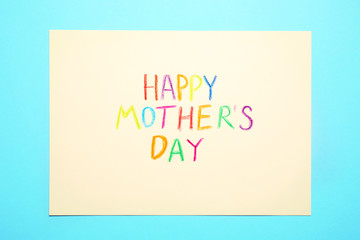 Greeting card with text Happy Mother's day on light blue background, top view