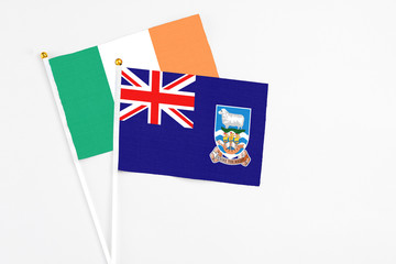 Falkland Islands and Ireland stick flags on white background. High quality fabric, miniature national flag. Peaceful global concept.White floor for copy space