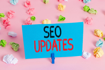 Handwriting text Seo Updates. Conceptual photo new information or design in search engine optimization Colored crumpled papers empty reminder pink floor background clothespin
