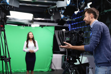 Obraz na płótnie Canvas Presenter and video camera operator working in studio. News broadcasting