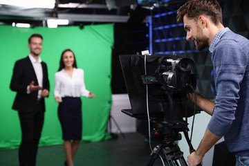Fototapeta na wymiar Presenters and video camera operator working in studio. News broadcasting