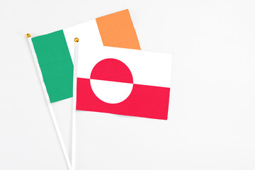 Greenland and Ireland stick flags on white background. High quality fabric, miniature national flag. Peaceful global concept.White floor for copy space