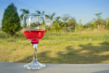 glass with red wine in rice field garden