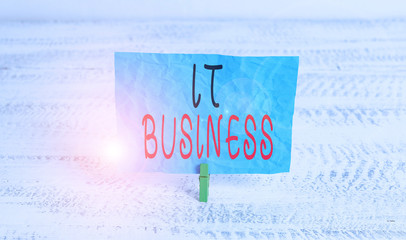 Word writing text It Business. Business photo showcasing organization uses information technology to achieve goals Green clothespin white wood background colored paper reminder office supply