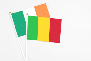 Mali and Ireland stick flags on white background. High quality fabric, miniature national flag. Peaceful global concept.White floor for copy space