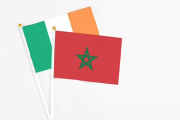 Morocco and Ireland stick flags on white background. High quality fabric, miniature national flag. Peaceful global concept.White floor for copy space