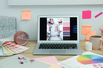 Designer's workplace with modern laptop and color palettes