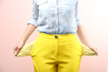 Woman showing empty pockets on pink background, closeup