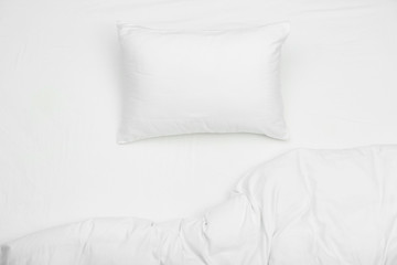 Soft white pillow and blanket on bed, top view