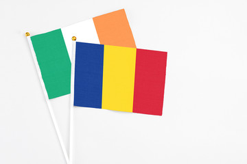 Romania and Ireland stick flags on white background. High quality fabric, miniature national flag. Peaceful global concept.White floor for copy space