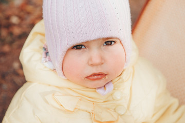 a little girl in a warm hat on his head smiled. the concept of childhood, health, IVF, cold time