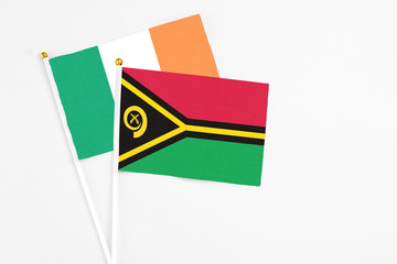 Vanuatu and Ireland stick flags on white background. High quality fabric, miniature national flag. Peaceful global concept.White floor for copy space