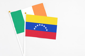 Venezuela and Ireland stick flags on white background. High quality fabric, miniature national flag. Peaceful global concept.White floor for copy space