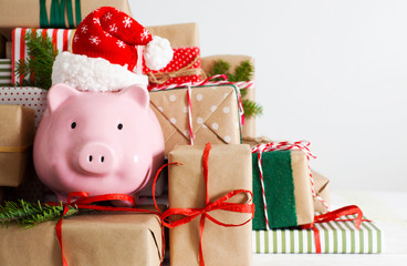 Piggy bank and a lot of gift boxes. Christmas decor. White background. Fir branches.