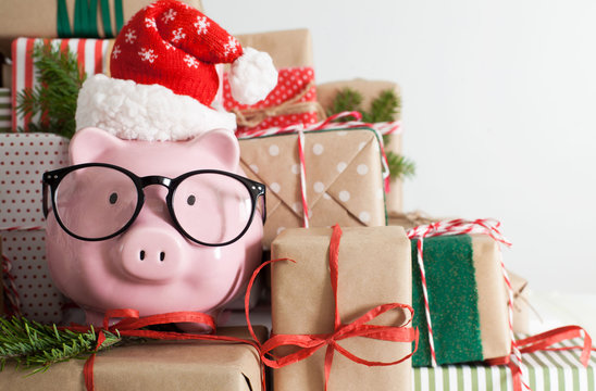 Piggy bank and a lot of gift boxes. Christmas decor. White background. Fir branches.
