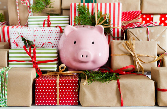 Piggy bank and a lot of gift boxes. Christmas decor. White background. Fir branches.