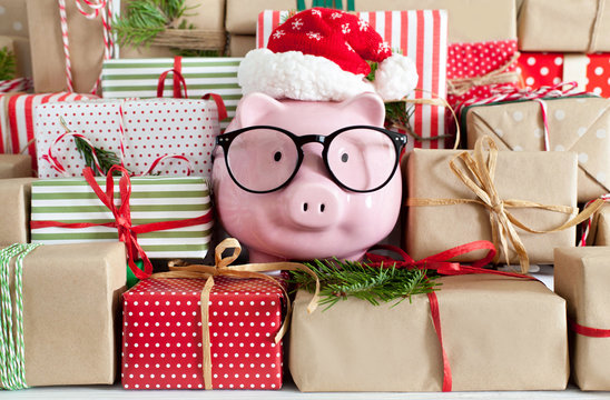 Piggy bank and a lot of gift boxes. Christmas decor. White background. Fir branches.