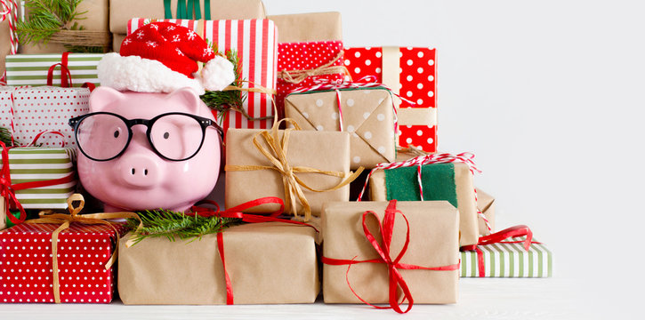 Piggy bank and a lot of gift boxes. Christmas decor. White background. Fir branches.