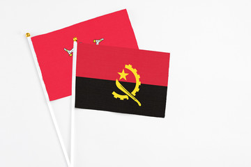 Angola and Isle Of Man stick flags on white background. High quality fabric, miniature national flag. Peaceful global concept.White floor for copy space.