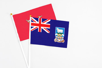 Falkland Islands and Isle Of Man stick flags on white background. High quality fabric, miniature national flag. Peaceful global concept.White floor for copy space.