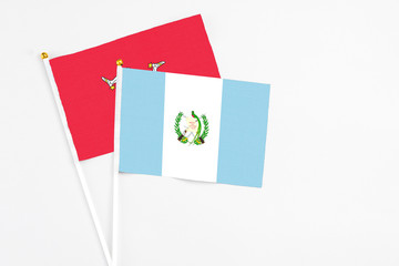 Guatemala and Isle Of Man stick flags on white background. High quality fabric, miniature national flag. Peaceful global concept.White floor for copy space.