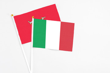 Italy and Isle Of Man stick flags on white background. High quality fabric, miniature national flag. Peaceful global concept.White floor for copy space.