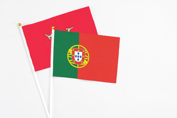 Portugal and Isle Of Man stick flags on white background. High quality fabric, miniature national flag. Peaceful global concept.White floor for copy space.