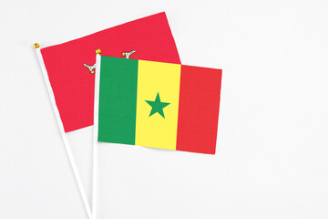 Senegal and Isle Of Man stick flags on white background. High quality fabric, miniature national flag. Peaceful global concept.White floor for copy space.