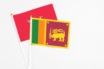 Sri Lanka and Isle Of Man stick flags on white background. High quality fabric, miniature national flag. Peaceful global concept.White floor for copy space.