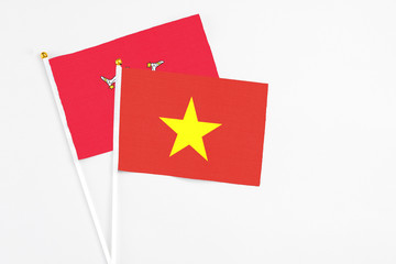 Vietnam and Isle Of Man stick flags on white background. High quality fabric, miniature national flag. Peaceful global concept.White floor for copy space.
