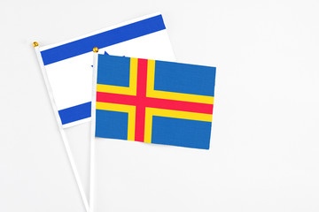Aland Islands and Israel stick flags on white background. High quality fabric, miniature national...