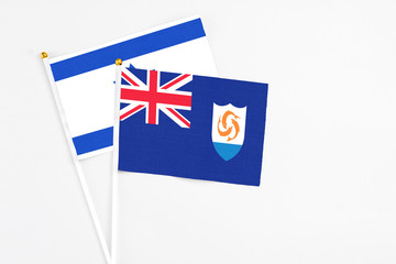 Fototapeta premium Anguilla and Israel stick flags on white background. High quality fabric, miniature national flag. Peaceful global concept.White floor for copy space.