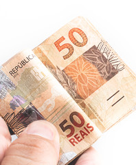 Real - Brazilian Currency. Shot of a man holding a group of 50 reais banknotes.
