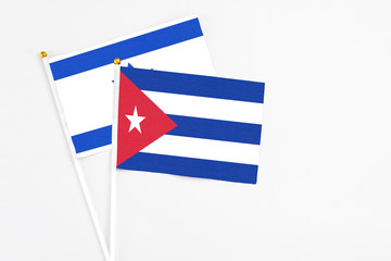 Cuba and Israel stick flags on white background. High quality fabric, miniature national flag. Peaceful global concept.White floor for copy space.
