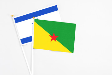 French Guiana and Israel stick flags on white background. High quality fabric, miniature national flag. Peaceful global concept.White floor for copy space.