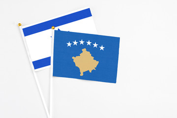 Kosovo and Israel stick flags on white background. High quality fabric, miniature national flag. Peaceful global concept.White floor for copy space.