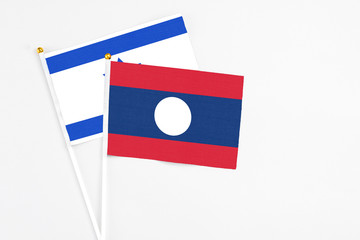 Laos and Israel stick flags on white background. High quality fabric, miniature national flag. Peaceful global concept.White floor for copy space.