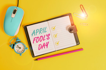 Word writing text April Fool S Day. Business photo showcasing Practical jokes humor pranks Celebration funny foolish Locked diary sheets clips marker mouse alarm clock colored background