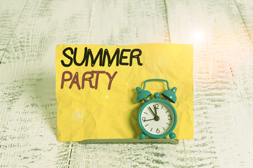 Word writing text Summer Party. Business photo showcasing social gathering held during summer season or school break Mini blue alarm clock stand tilted above buffer wire in front of notepaper