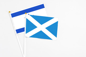 Scotland and Israel stick flags on white background. High quality fabric, miniature national flag. Peaceful global concept.White floor for copy space.