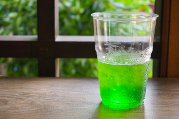 glass of water with lime and ice on wooden table
