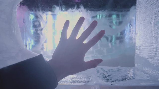 Male hand put on translucent ice wall longing to get out, slow motion