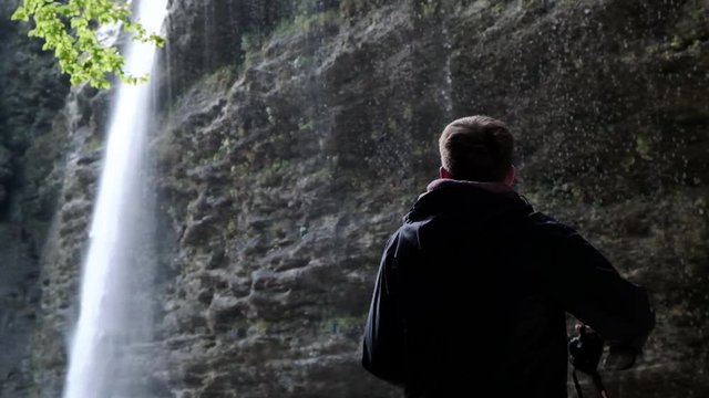 The beautiful waterfall of Pericnik Waterfall in Slovenia. Man capturing a image of the waterfall falling in slow motion