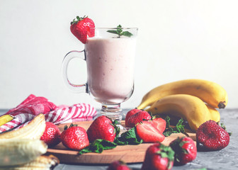 banana and strawberry smoothies with mint on the table, front view