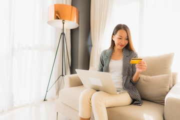 Portrait beautiful young asian women using computer laptop or smart and mobile phone with credit card for online shopping