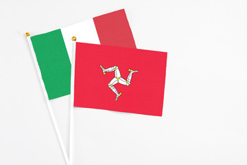 Isle Of Man and Italy stick flags on white background. High quality fabric, miniature national flag. Peaceful global concept.White floor for copy space.